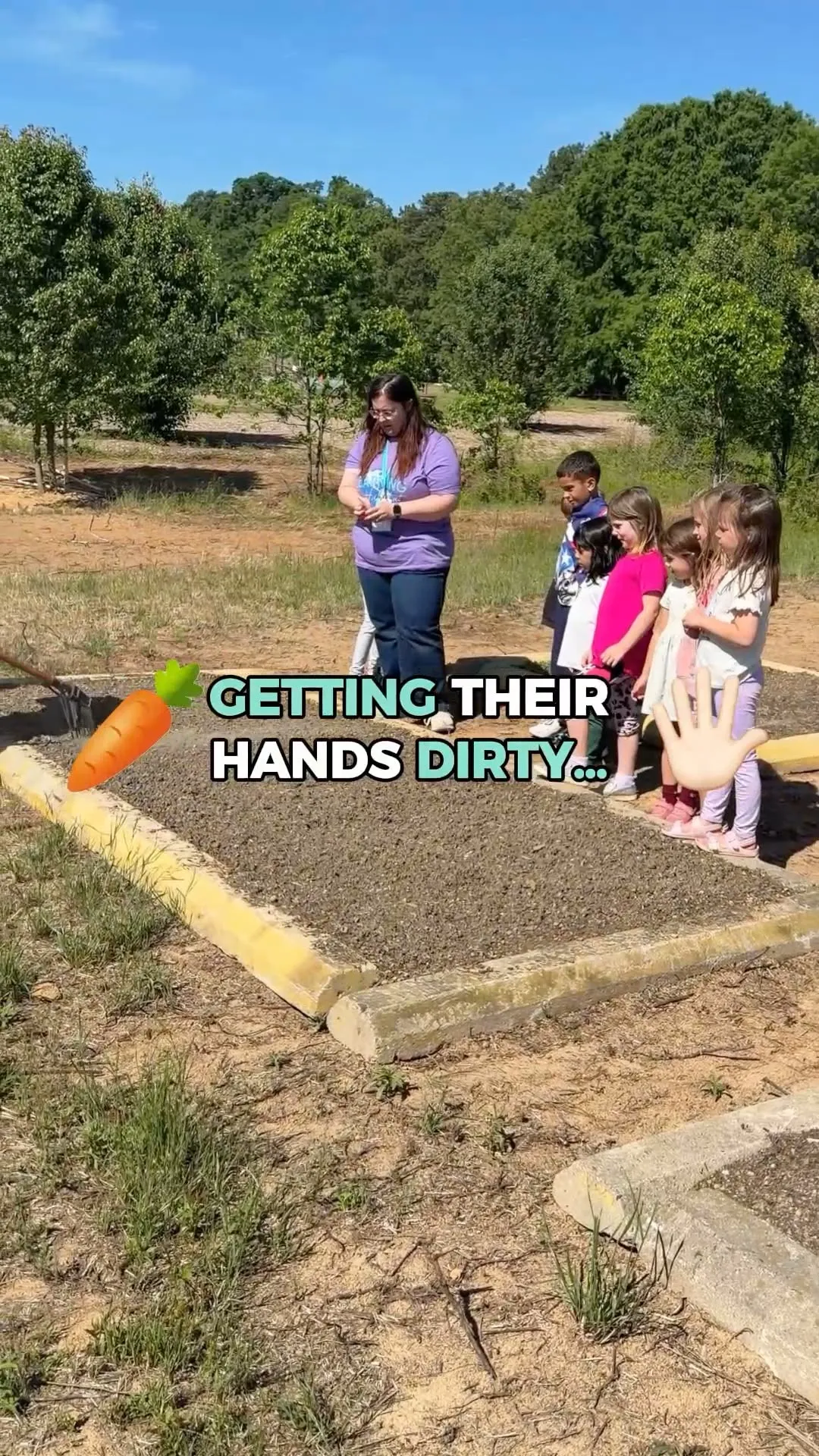 Children exploring and learning together beside a garden bed
