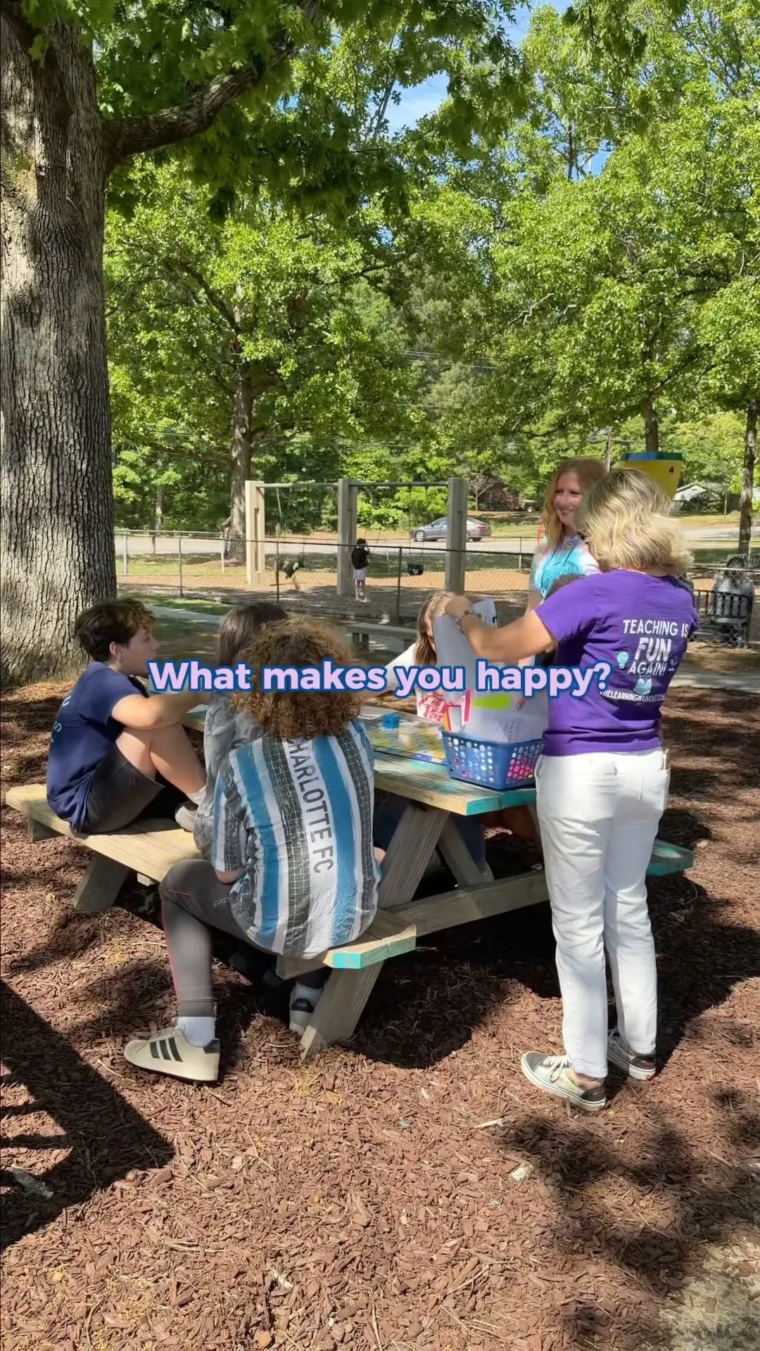 Children and teachers spending time together at an outdoor table
