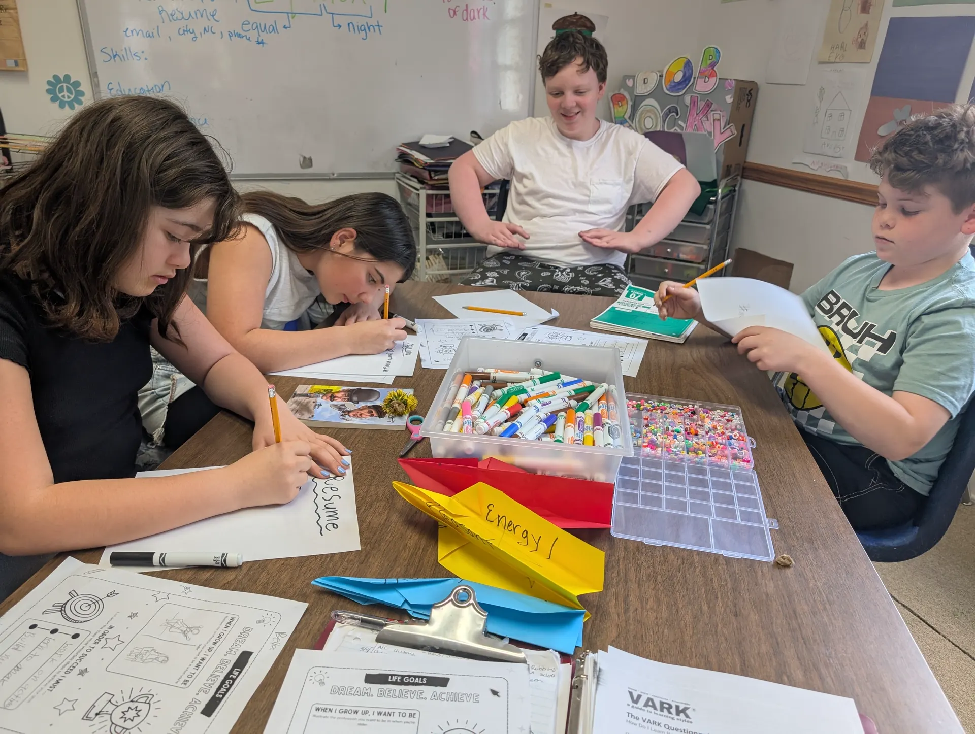Learning Habitat students writing, planning, and creating together around a classroom table